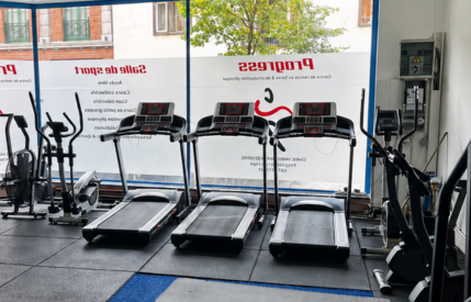 Espace cardio du cabinet de kinésithérapie avec plusieurs tapis de course alignés devant de grandes fenêtres